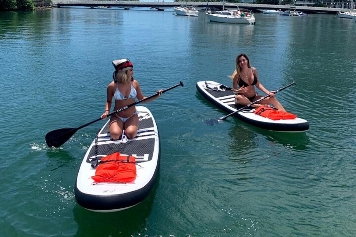 two women are sitting on kayaks in the water