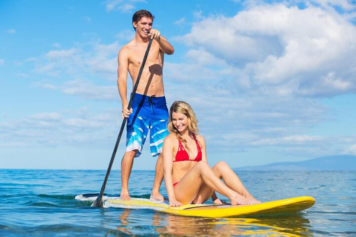 a man and a woman on a paddle board in the water