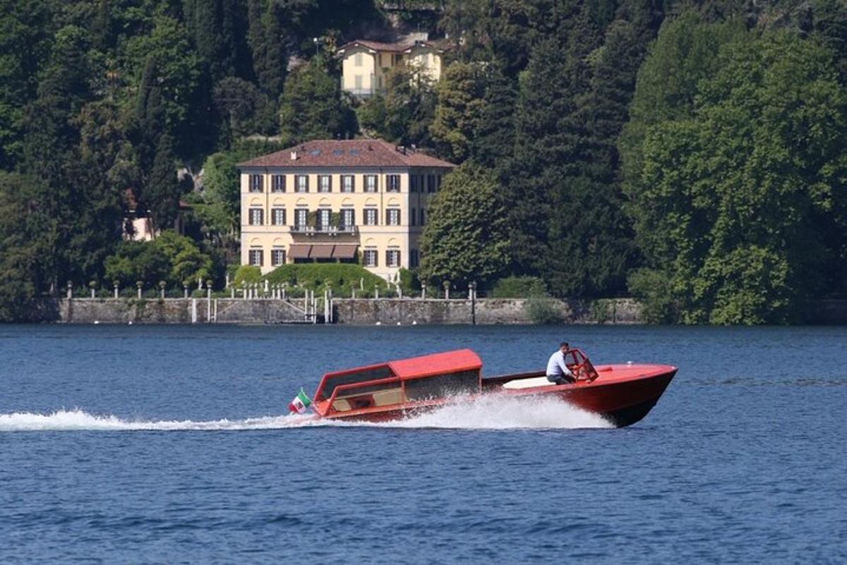 una barca rossa nell'acqua davanti a una casa