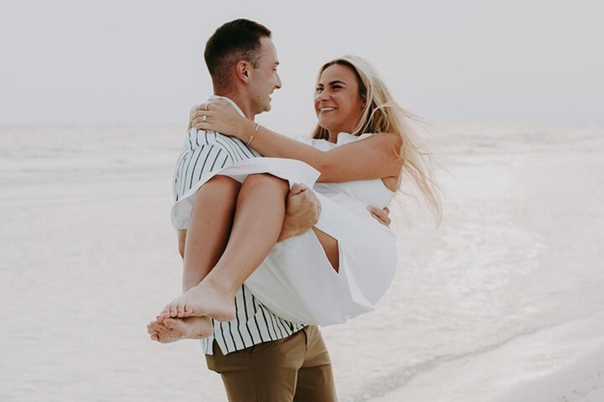 a man carrying a woman on the beach