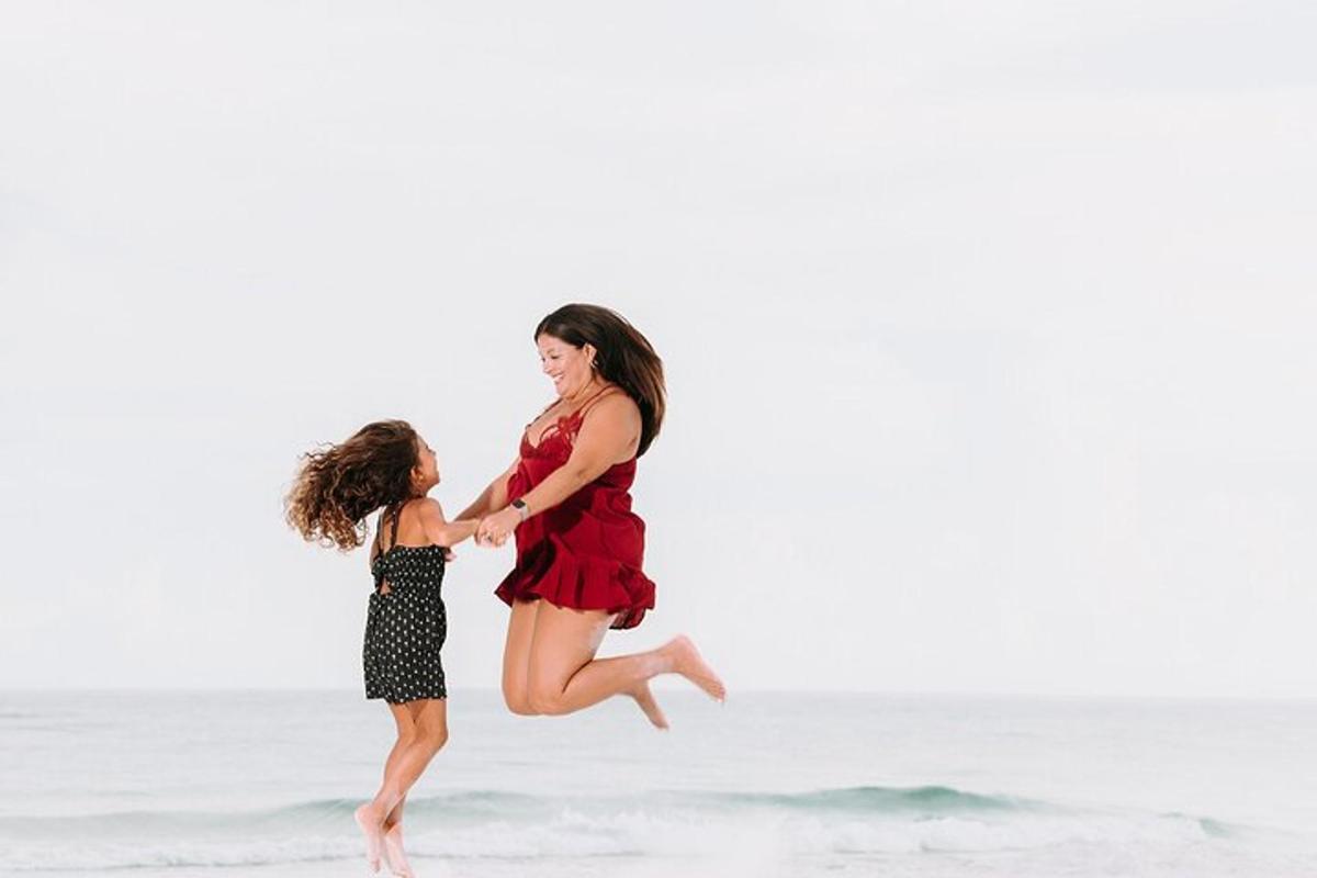 a woman and a little girl running on the beach