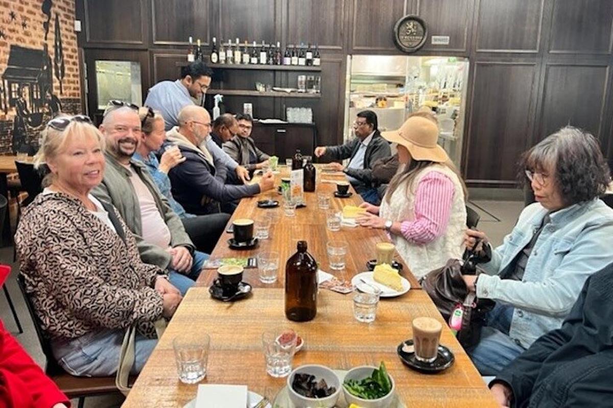 egy csoport ember ül egy hosszú asztal körül