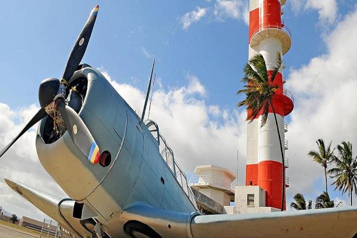 a small plane parked next to a lighthouse