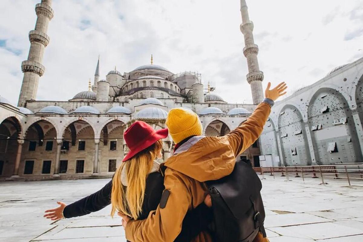 un homme et une femme debout devant une mosquée