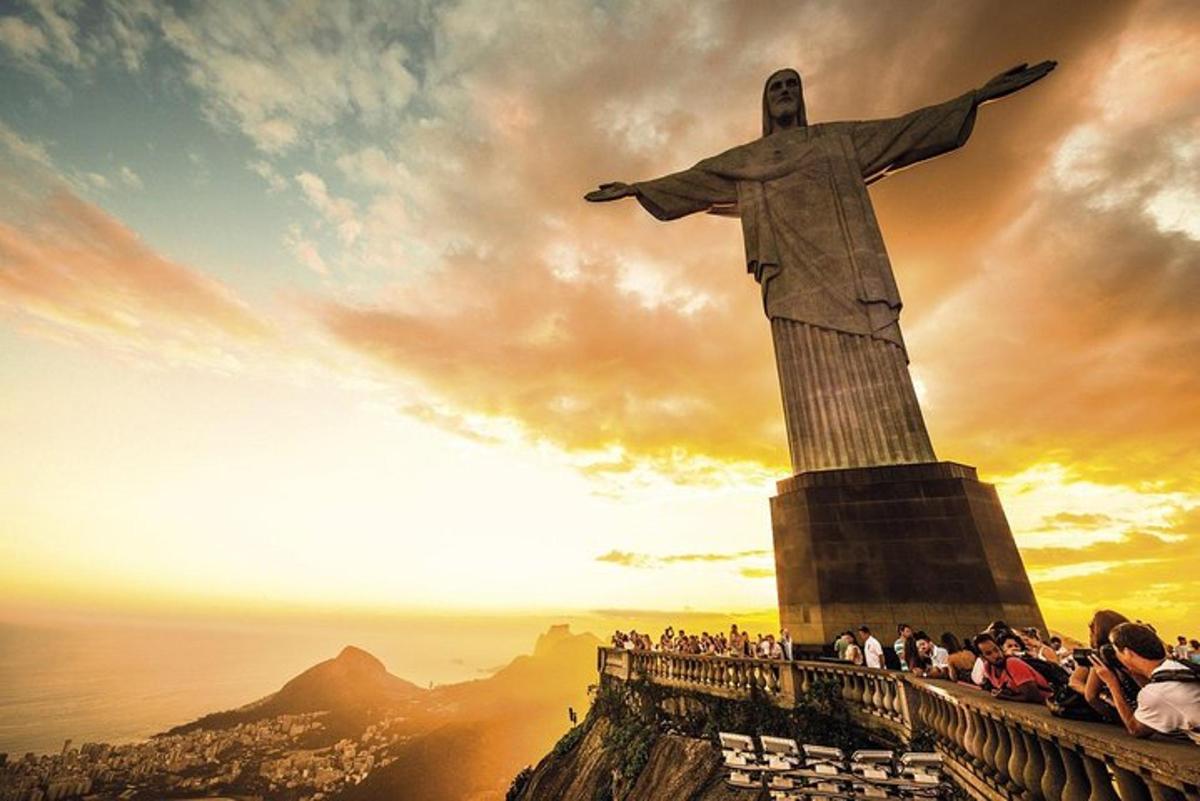 un gruppo di persone in piedi attorno alla statua del Cristo Redentore