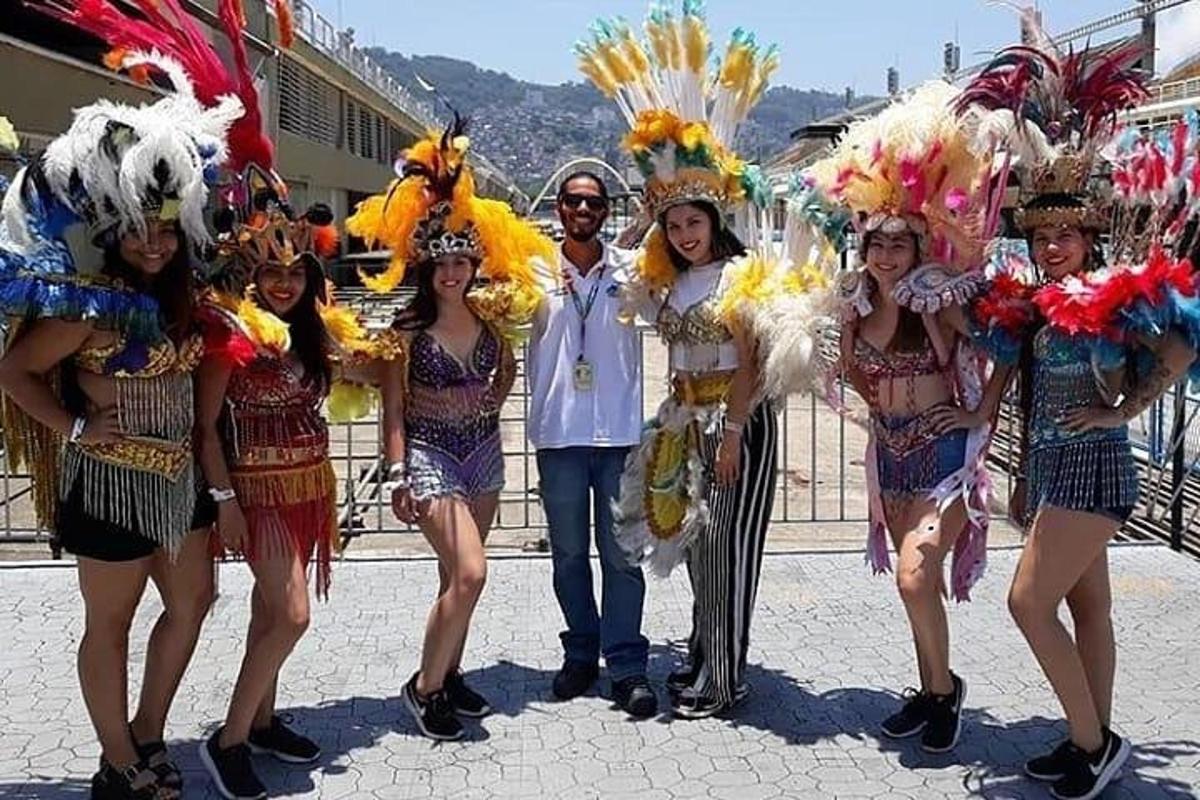 un uomo in piedi accanto a un gruppo di ragazze in costume
