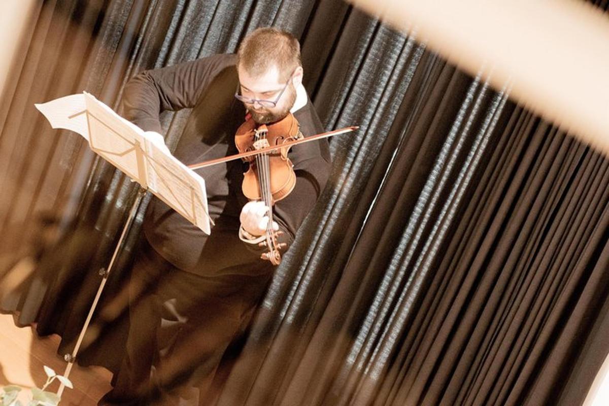 a man playing aviolin while holding a book
