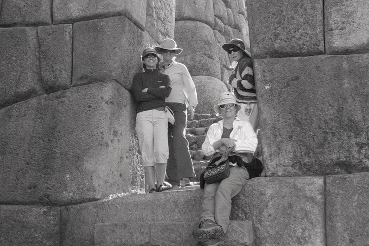 a group of people standing next to a stone wall