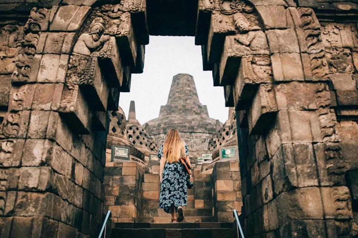 une femme montant un escalier menant à un temple