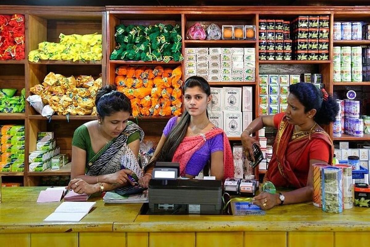 três mulheres sentadas na caixa registradora de um supermercado