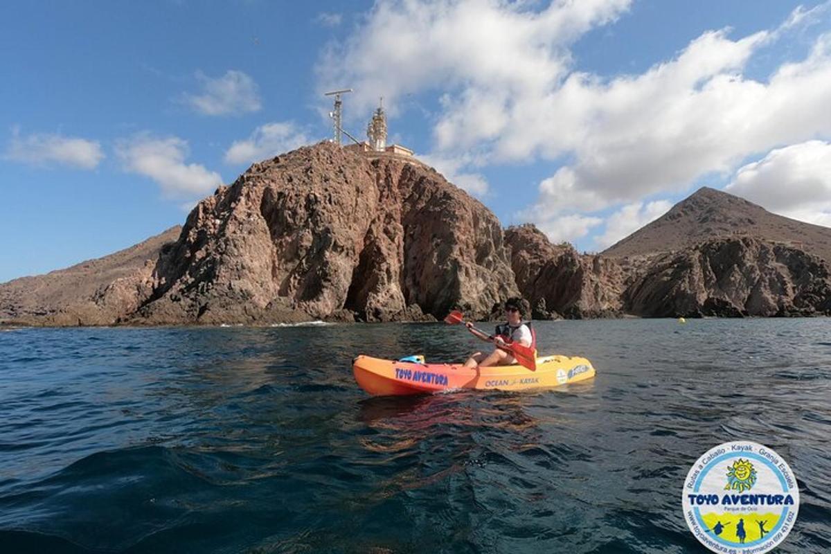 a person in a kayak in the water in front of an island