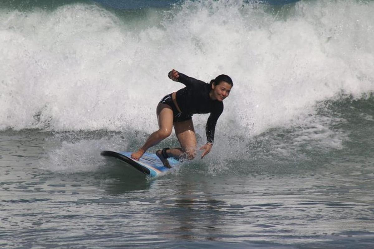 a woman riding a wave on a surfboard in the ocean