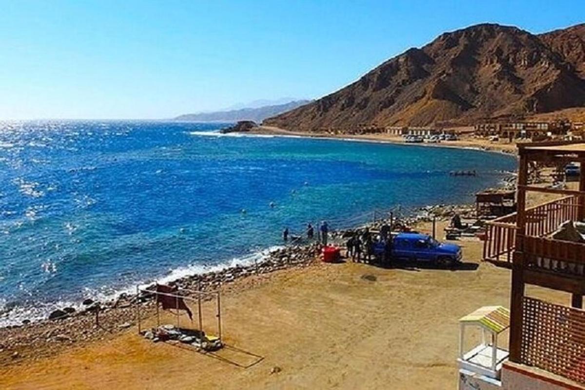 Una playa con un grupo de personas y el océano.