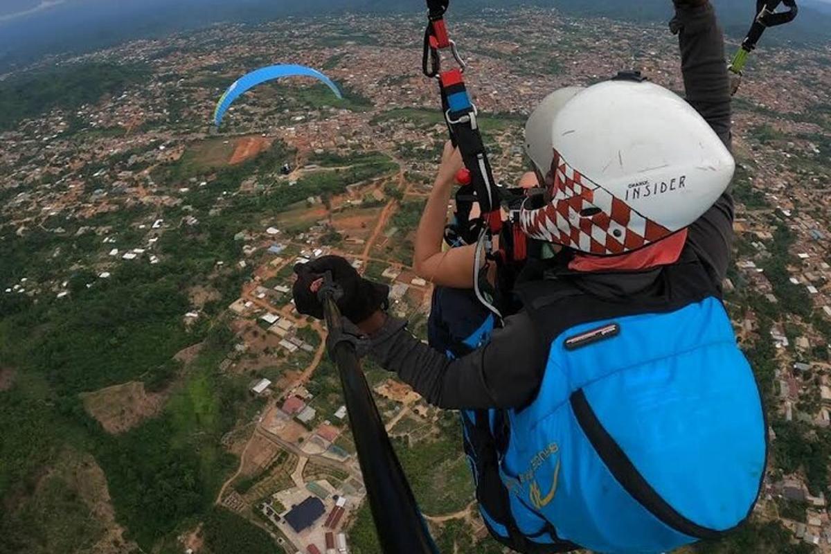 a person flying a parachute over a city