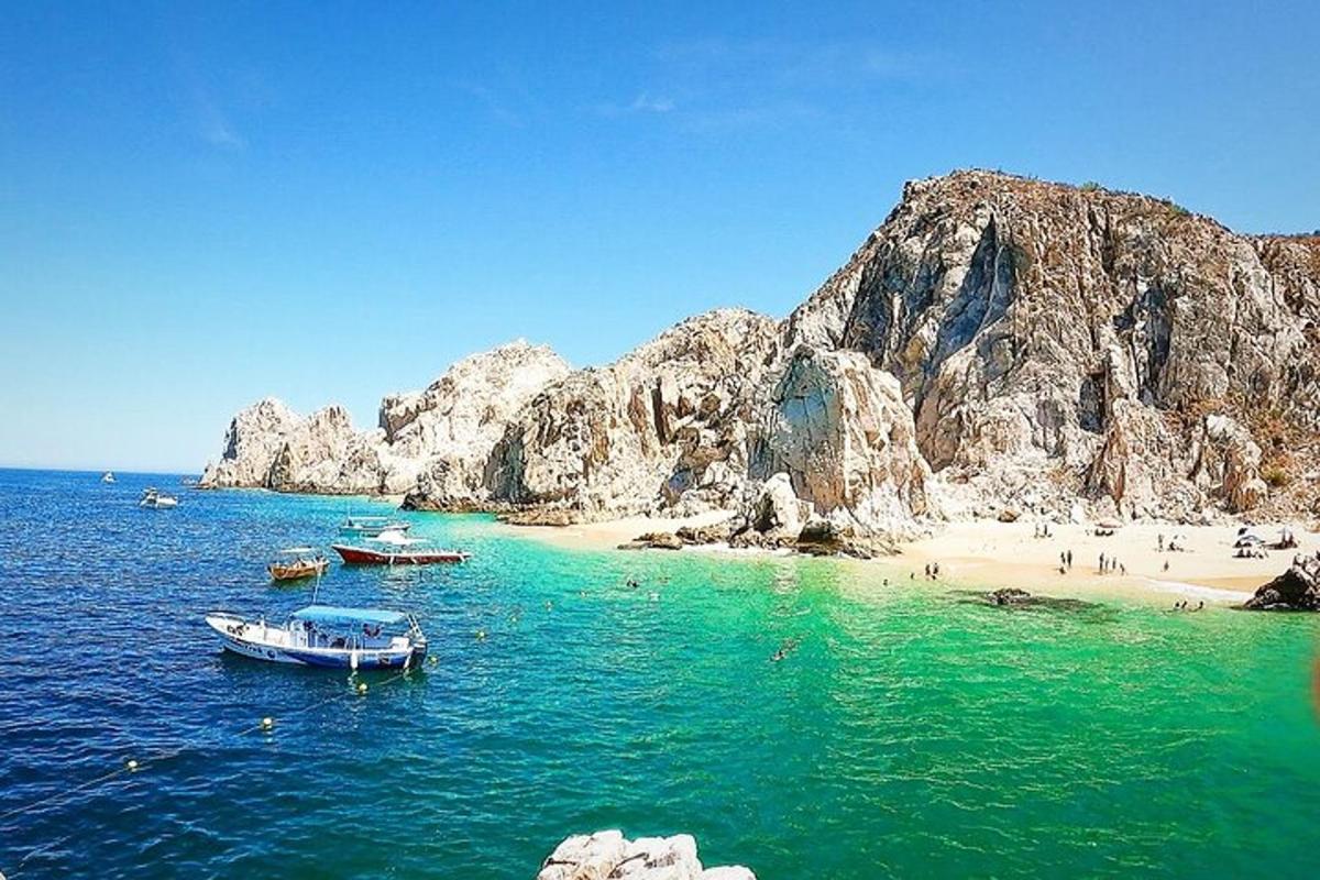 pantai dengan bot di dalam air dan orang di pantai