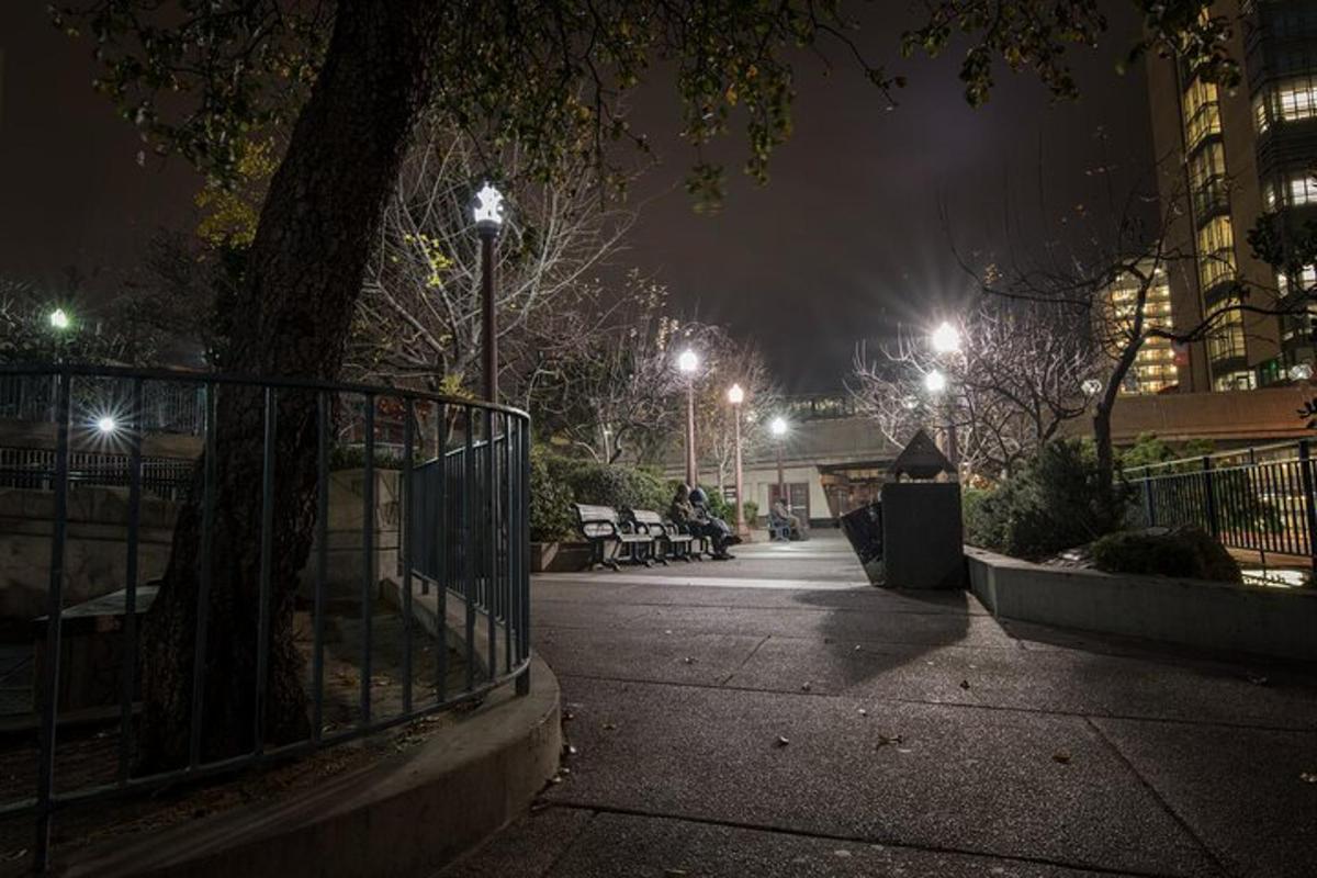 ένα πάρκο τη νύχτα με παγκάκια και φώτα του δρόμου