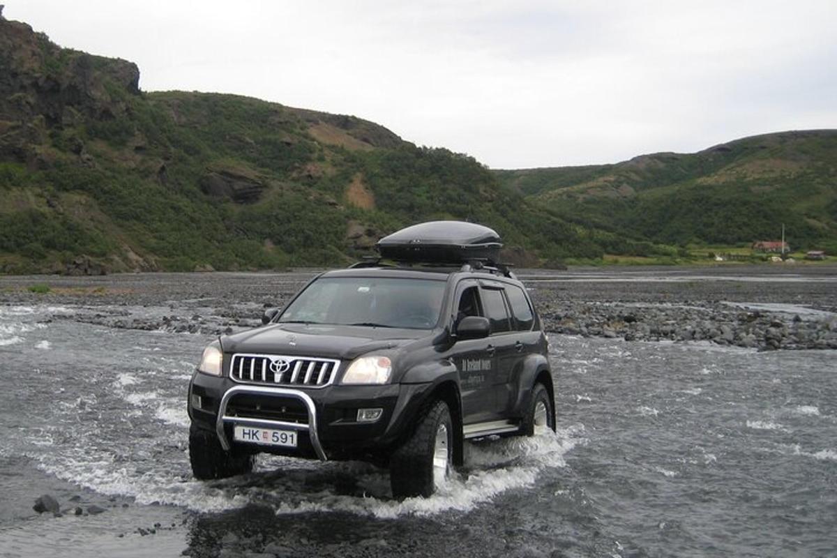 một chiếc xe suv đang lái qua một con sông trong nước