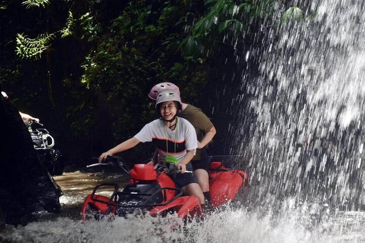 un ragazzino che pedala su una bicicletta d'acqua sotto una cascata