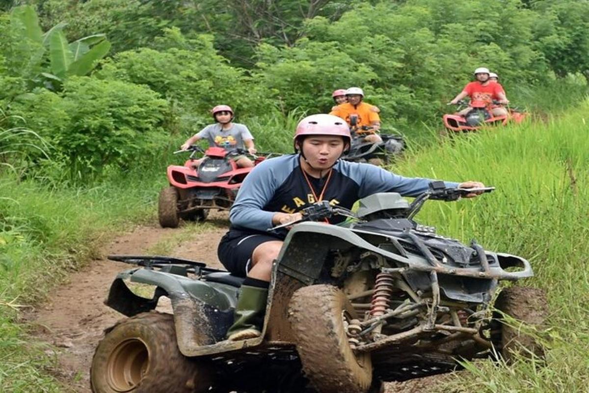 um grupo de pessoas andando de quadriciclo por uma estrada de terra