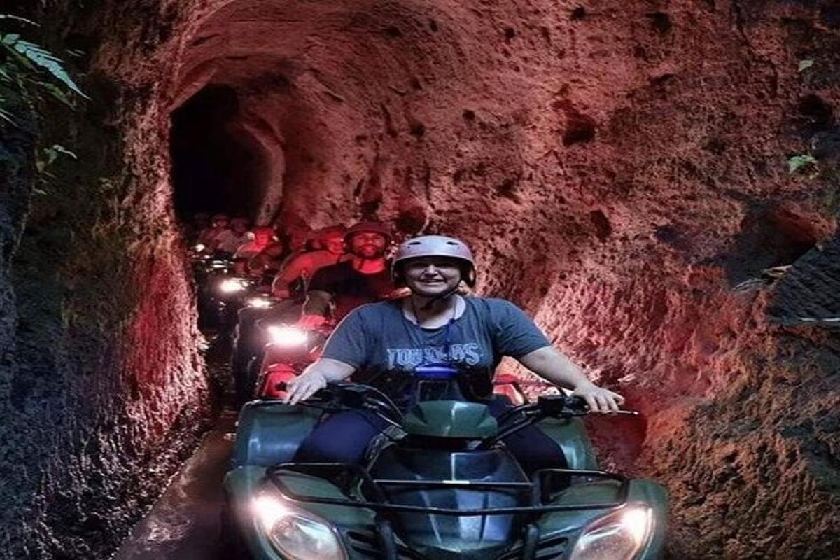 мъж, каращ ATV през тунел