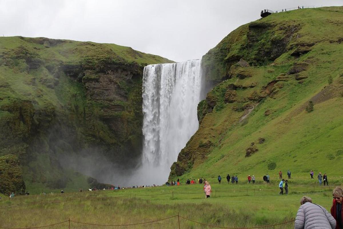um grupo de pessoas em pé em frente a uma cachoeira