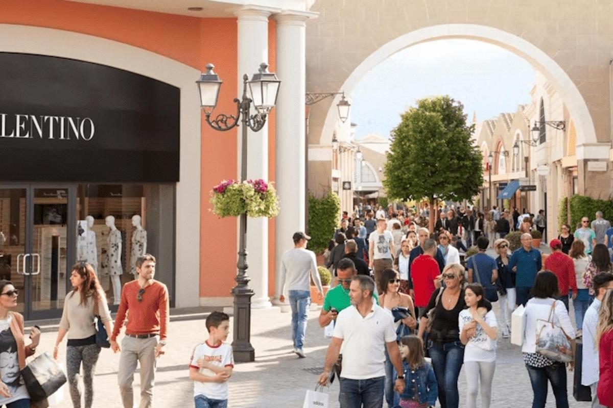 a crowd of people walking down a shopping street