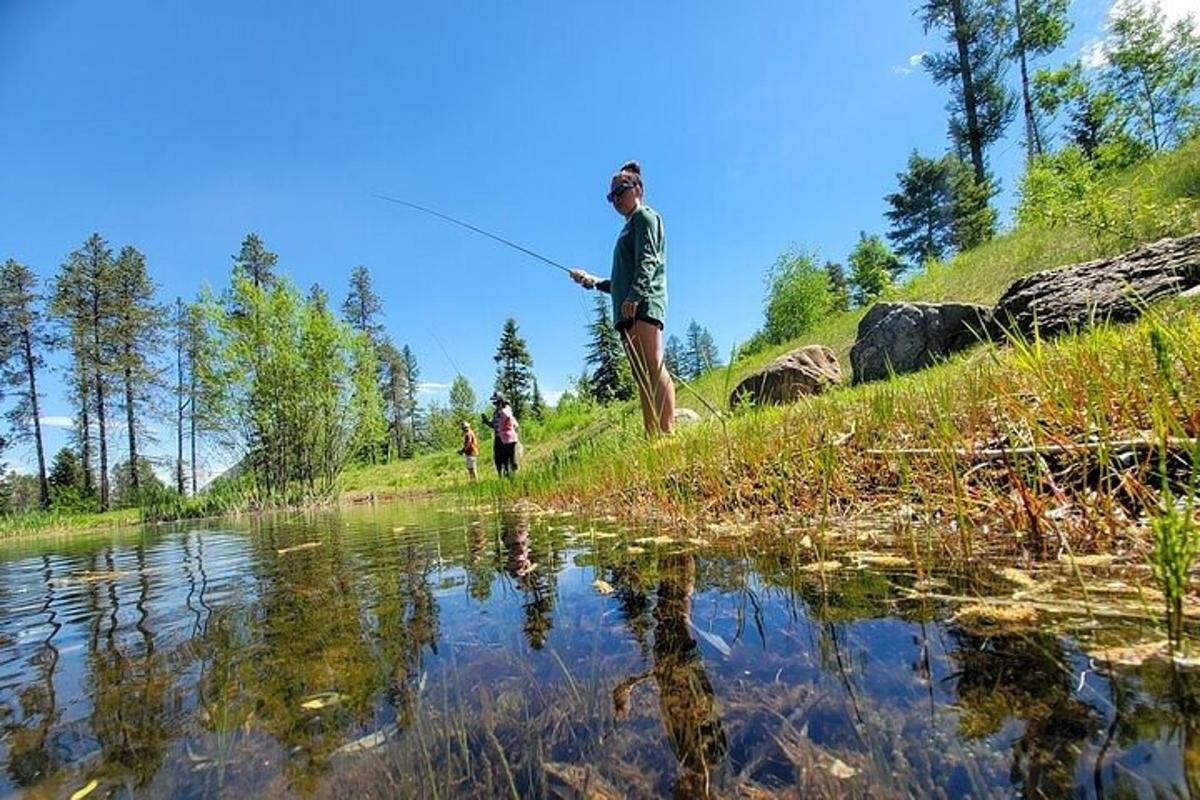 a man is standing next to a pond fishing