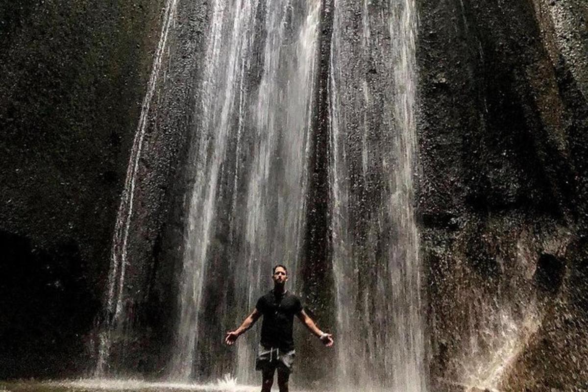 un uomo in piedi davanti a una cascata