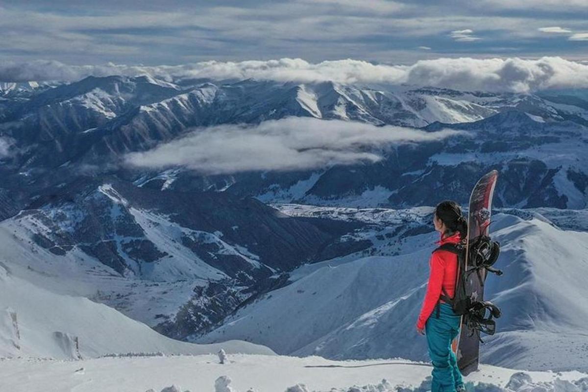 una donna in piedi in cima a uno snowboard su una montagna