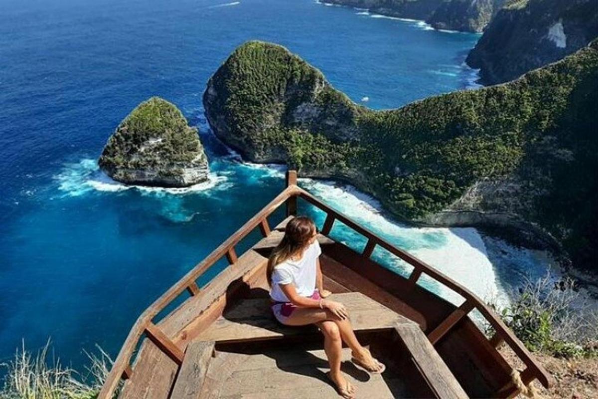 a woman sitting on a stairway looking out over the ocean