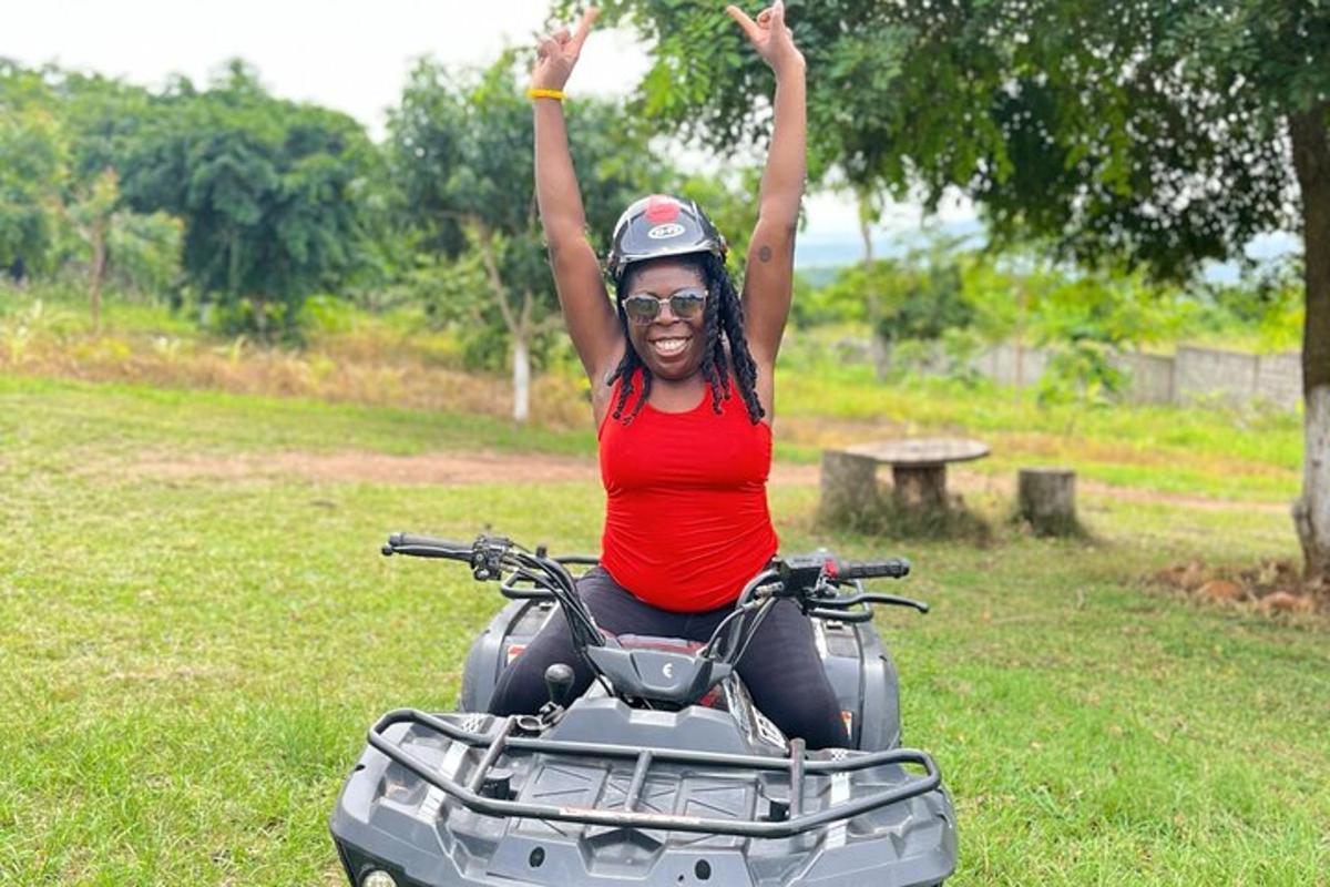 a woman riding a quad bike with her arms in the air