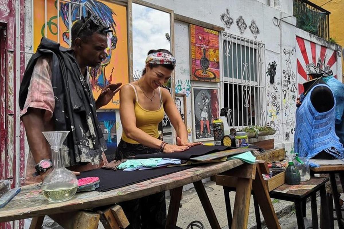 a man and a woman working on a piece of art on a table