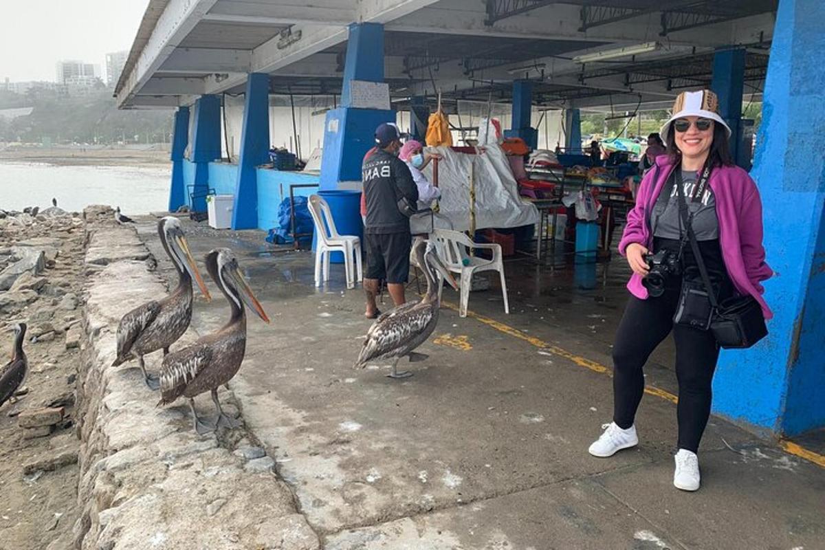 một người phụ nữ đứng cạnh những con chim trong chợ