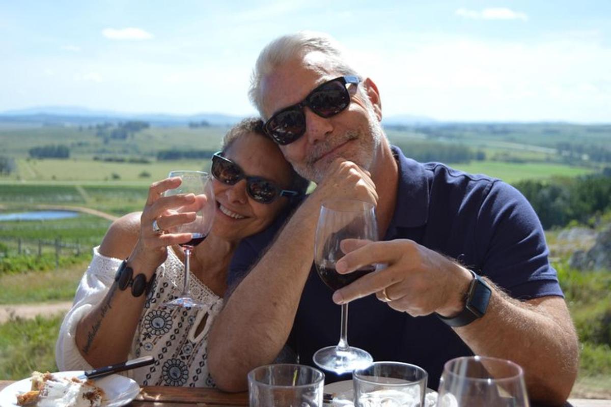 un uomo e una donna seduti a un tavolo con bicchieri di vino