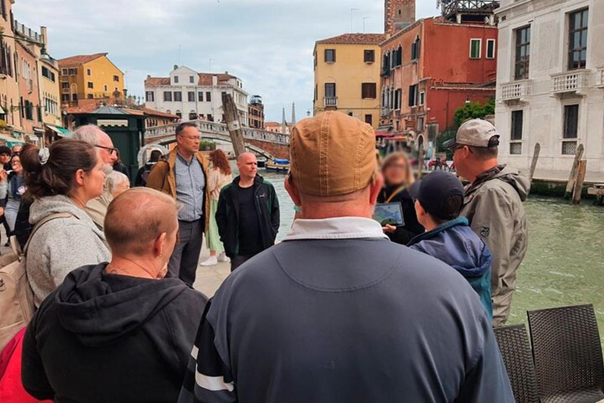 un grup de oameni care stau pe un trotuar lângă un râu