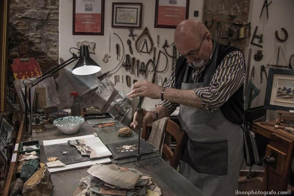 un uomo con un grembiule che taglia il cibo su un tavolo