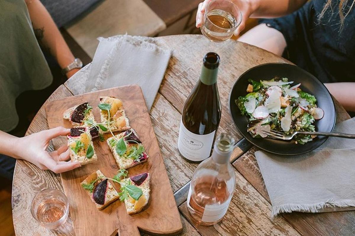 uma mesa com um prato de comida e uma garrafa de vinho