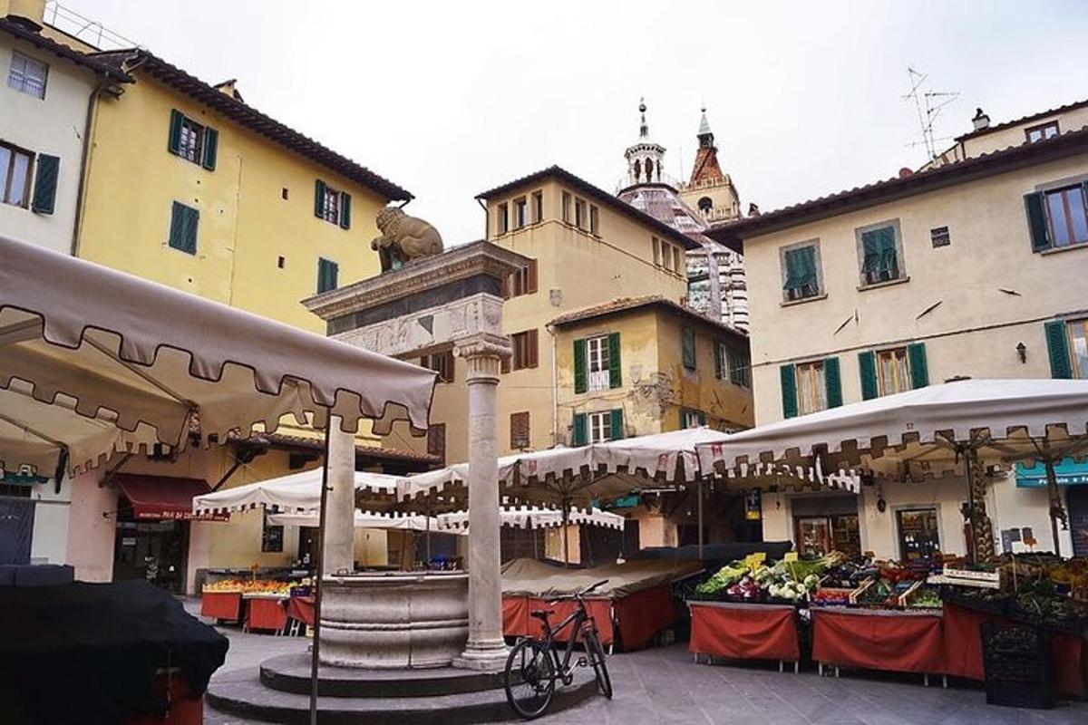 un mercato in una città con tavoli e ombrelloni