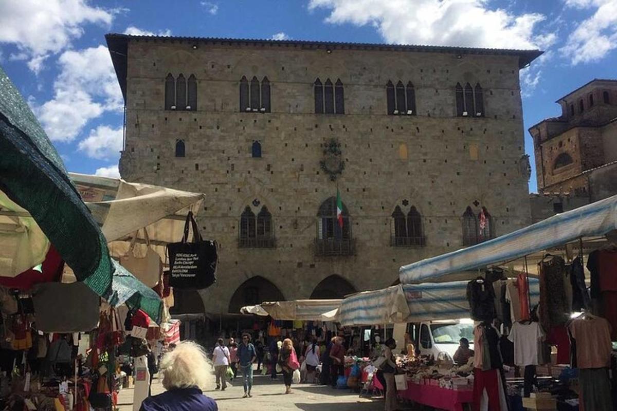 una folla di persone che camminano intorno a un mercato di fronte a un edificio