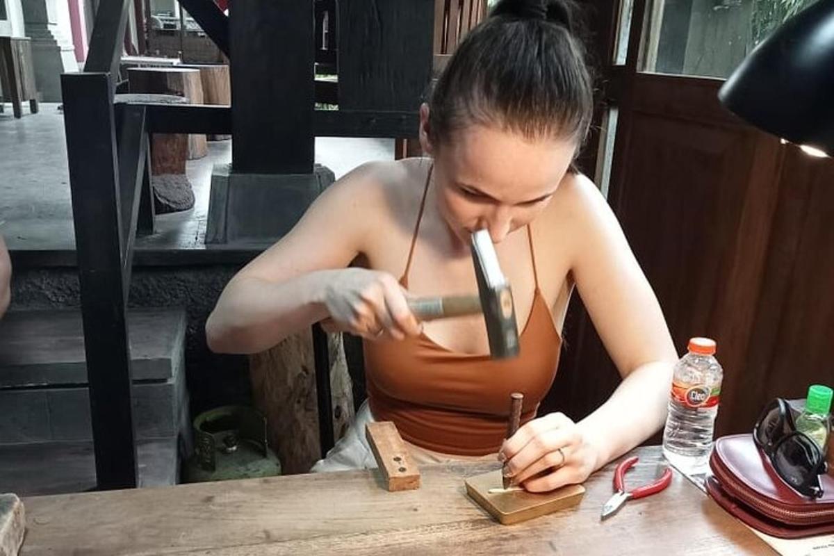 o femeie așezată la o masă tăind o bucată de lemn