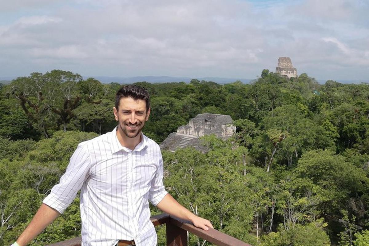 a man standing in front of the mayan ruins