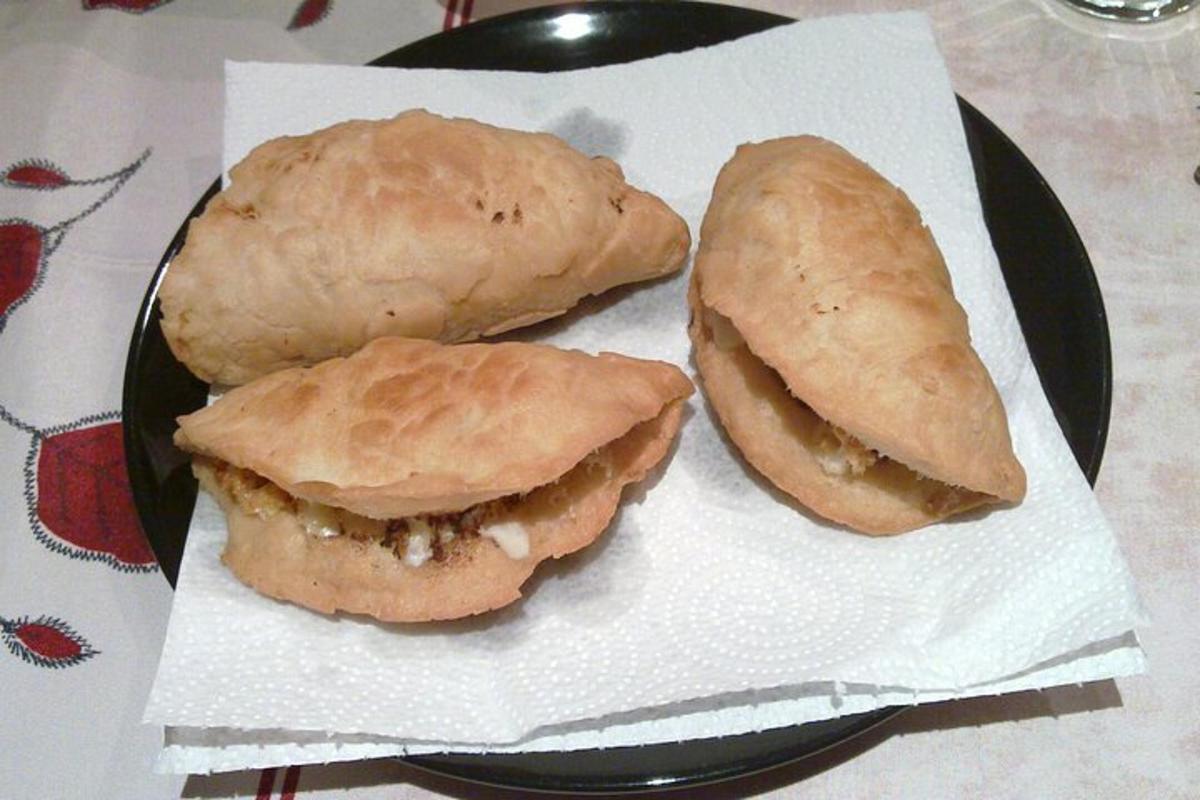 două sandvișuri pe o farfurie neagră pe o masă