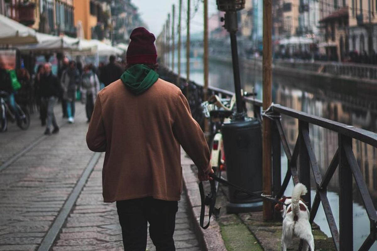 una persona che porta a spasso un cane al guinzaglio