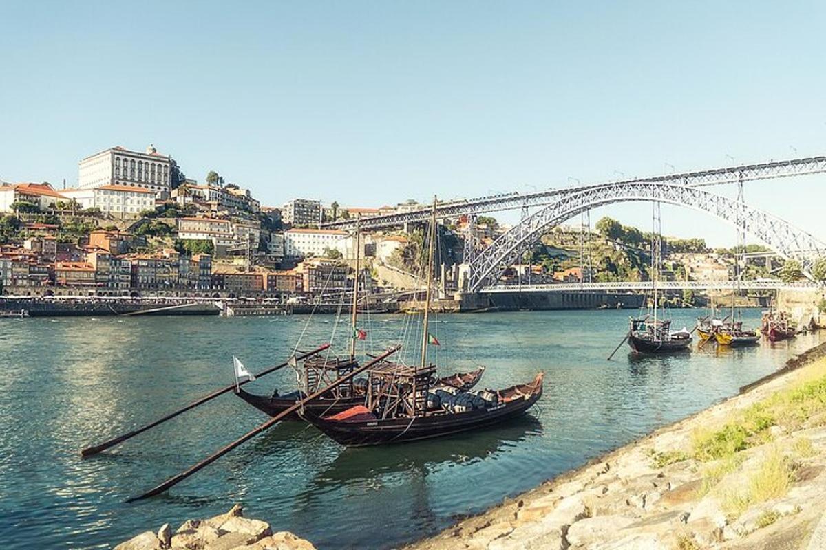 Τρεις βάρκες είναι αγκυροβολημένες στο νερό κοντά σε μια γέφυρα
