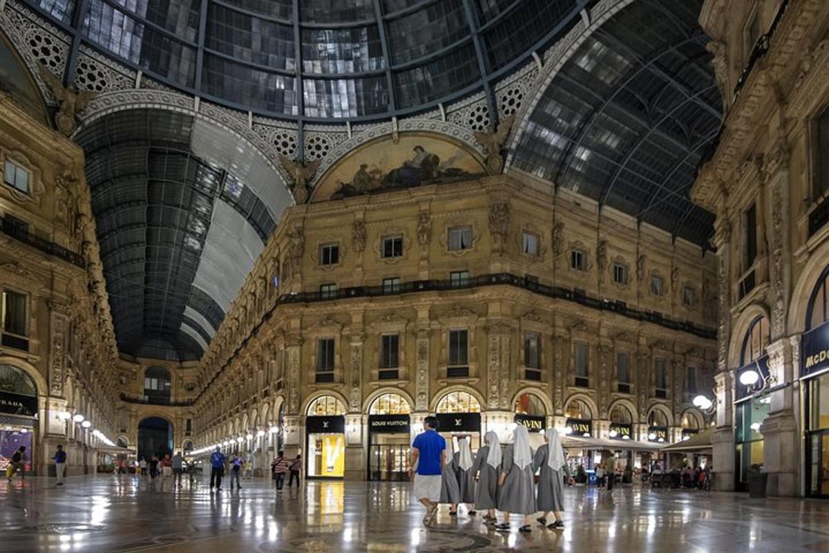 un grande edificio con un soffitto a cupola con persone che camminano al suo interno