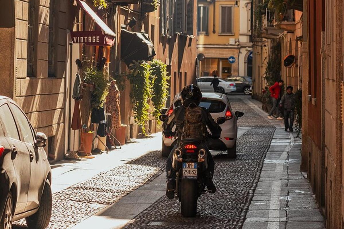 osoba jazdiaca na motorke po úzkej ulici