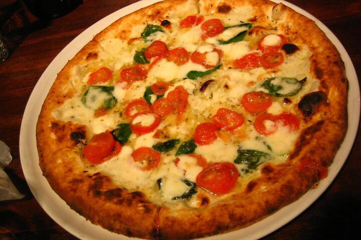 pizza á hvítum diski á borði