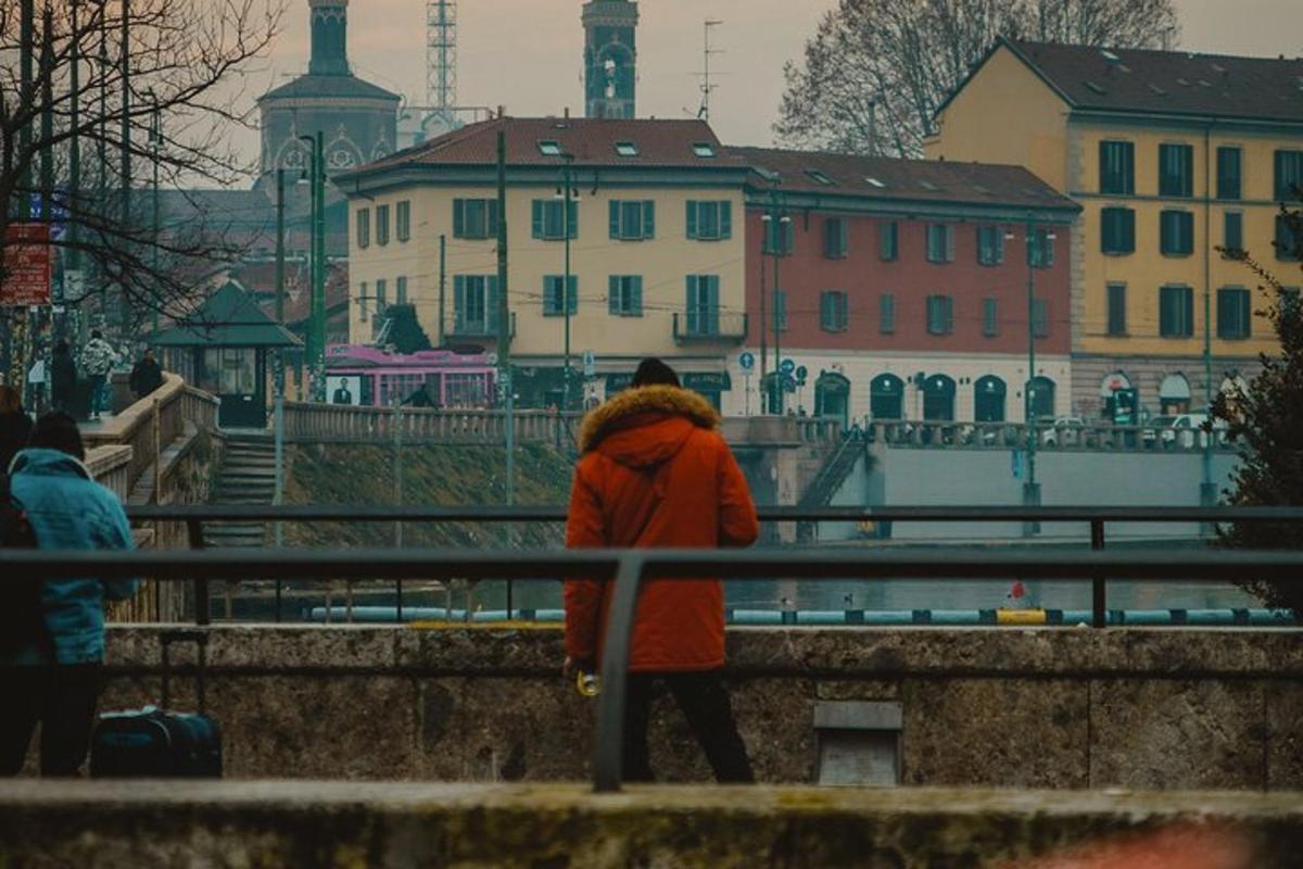 una persona con una giacca rossa che cammina su un ponte