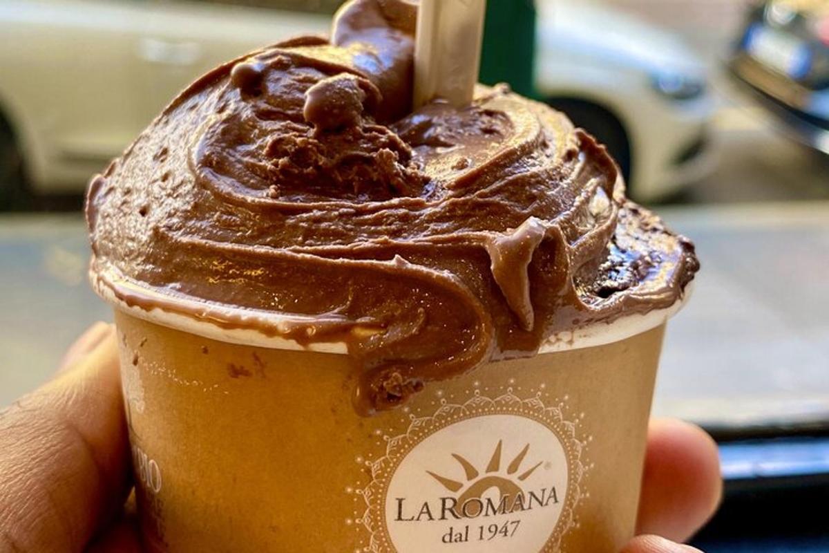 una mano che tiene una tazza di frullato al cioccolato