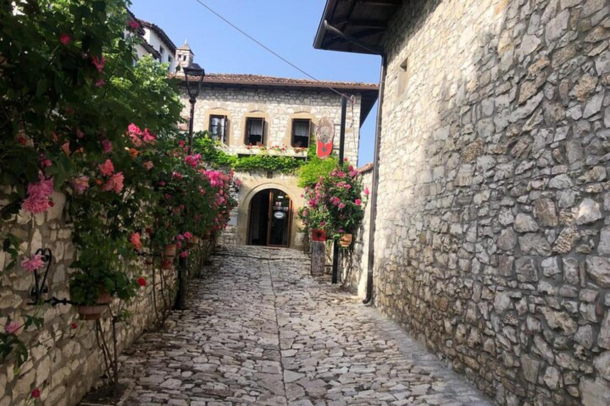un carreró en un antic edifici de pedra amb flors